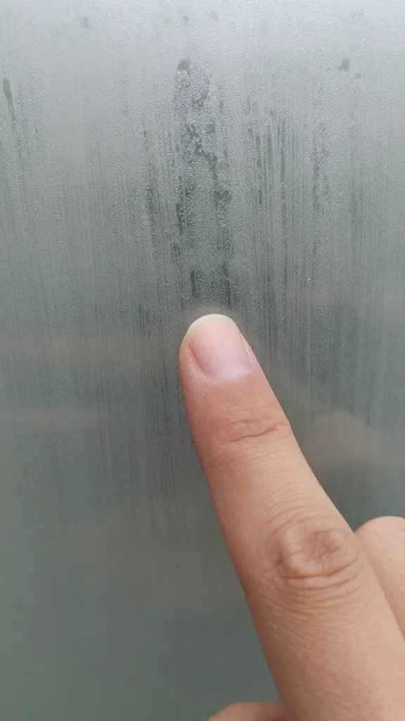 fingertip touching fogged terrarium glass, macro