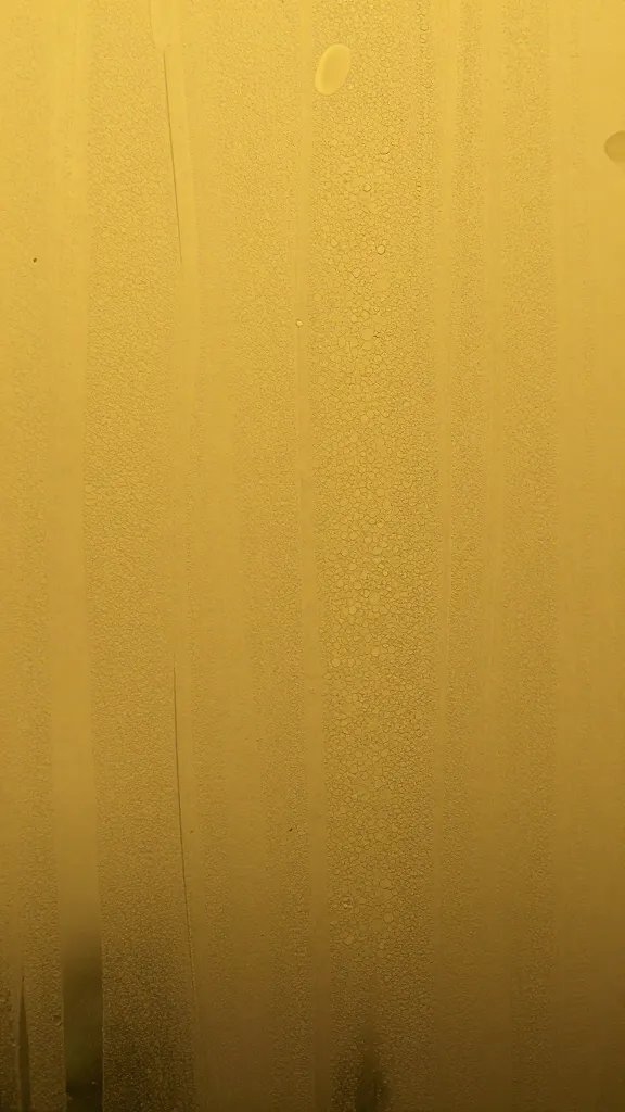 macro shot of yellowed water film on terrarium glass