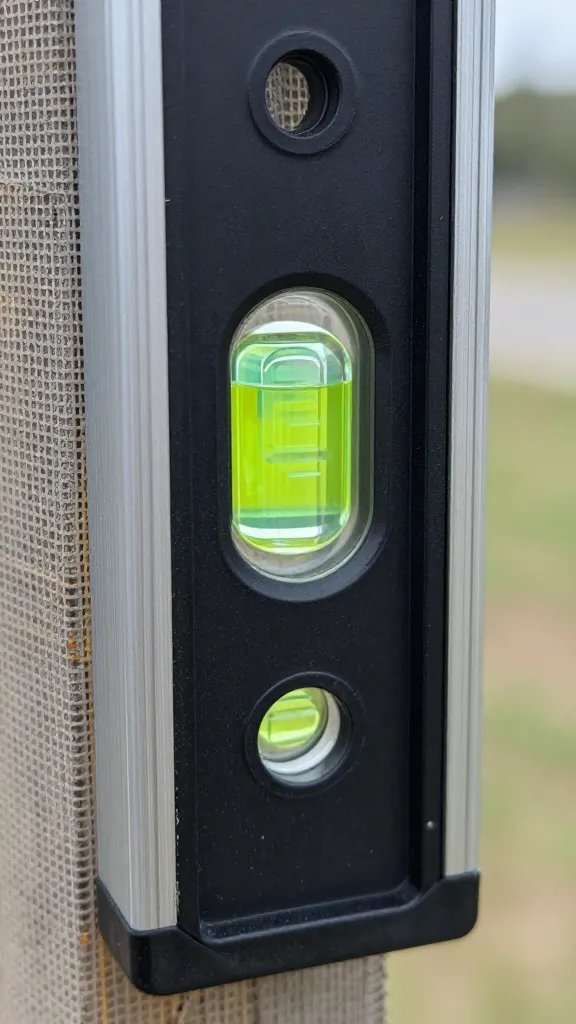 level bubble on trellis post checking plumb, closeup