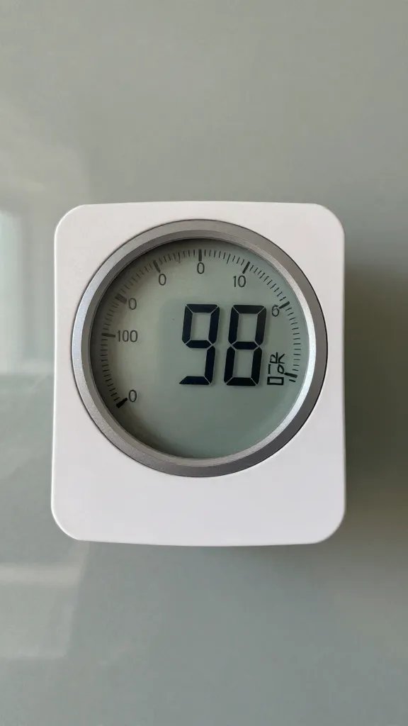 hygrometer face reading low humidity beside glass wall