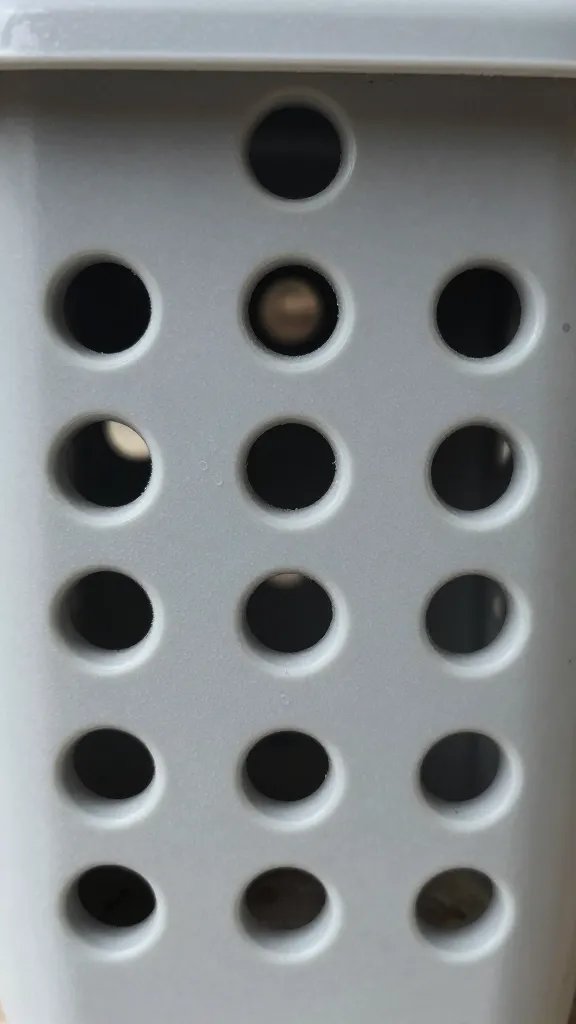 aeration holes in plastic planter wall, closeup