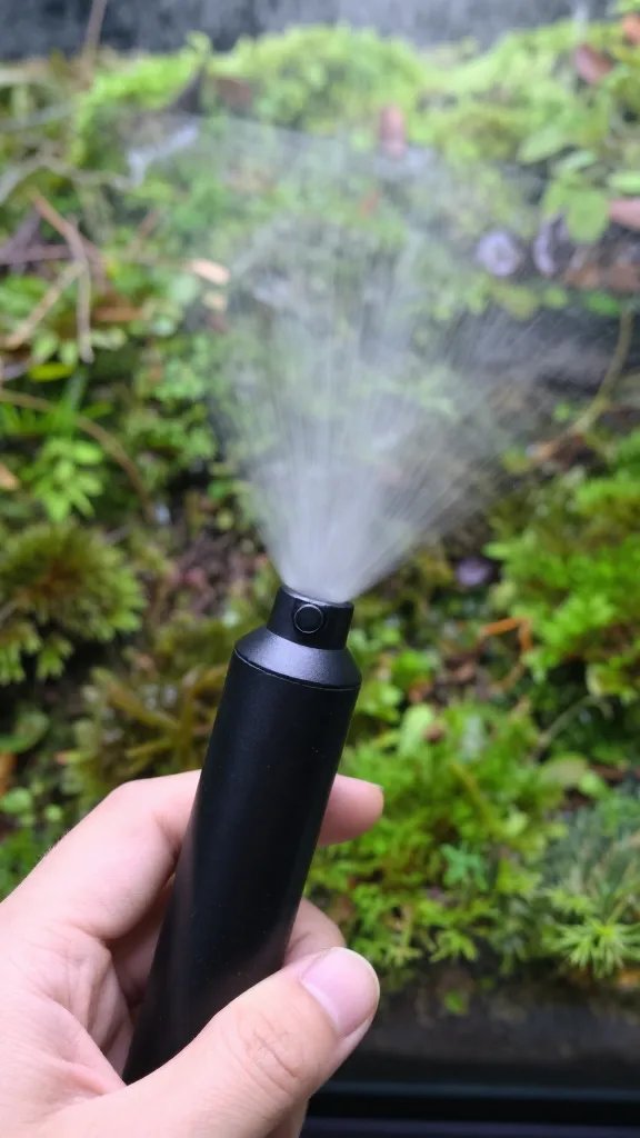 hand-held mister fogging terrarium moss, closeup