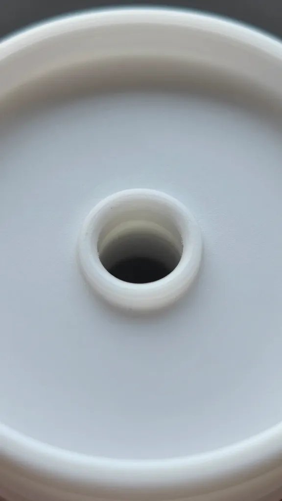 single drainage hole drilled in plastic lid, macro
